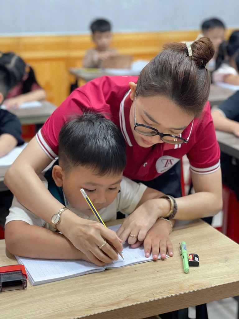 Cô Trâm Anh hướng dẫn học sinh viết chữ